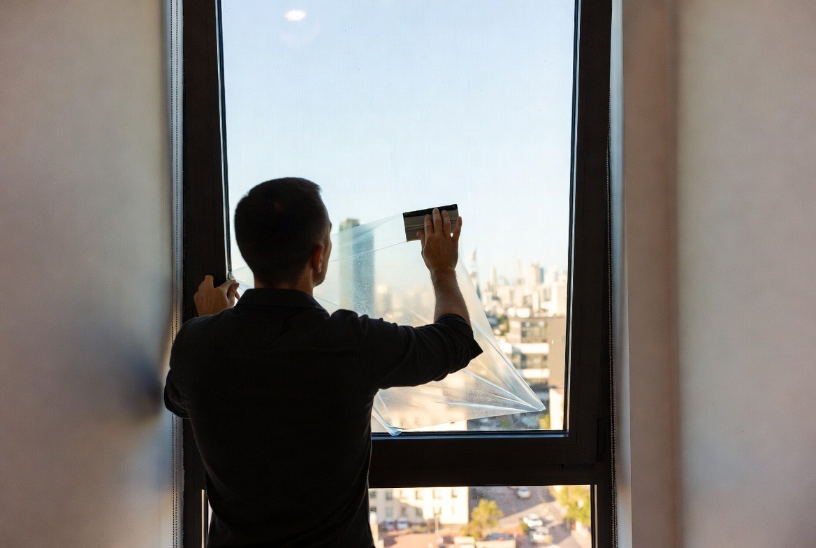 person-install-window-film-on-glass