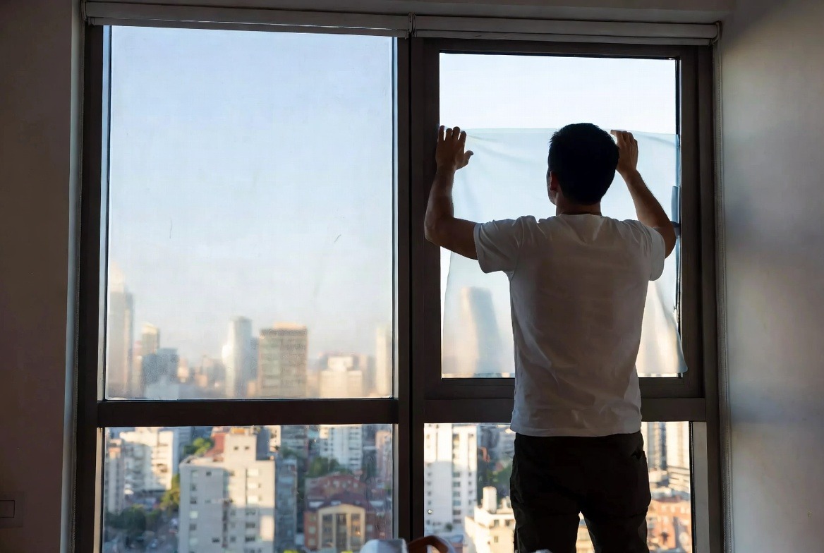 person-installing-window-film-on-glass